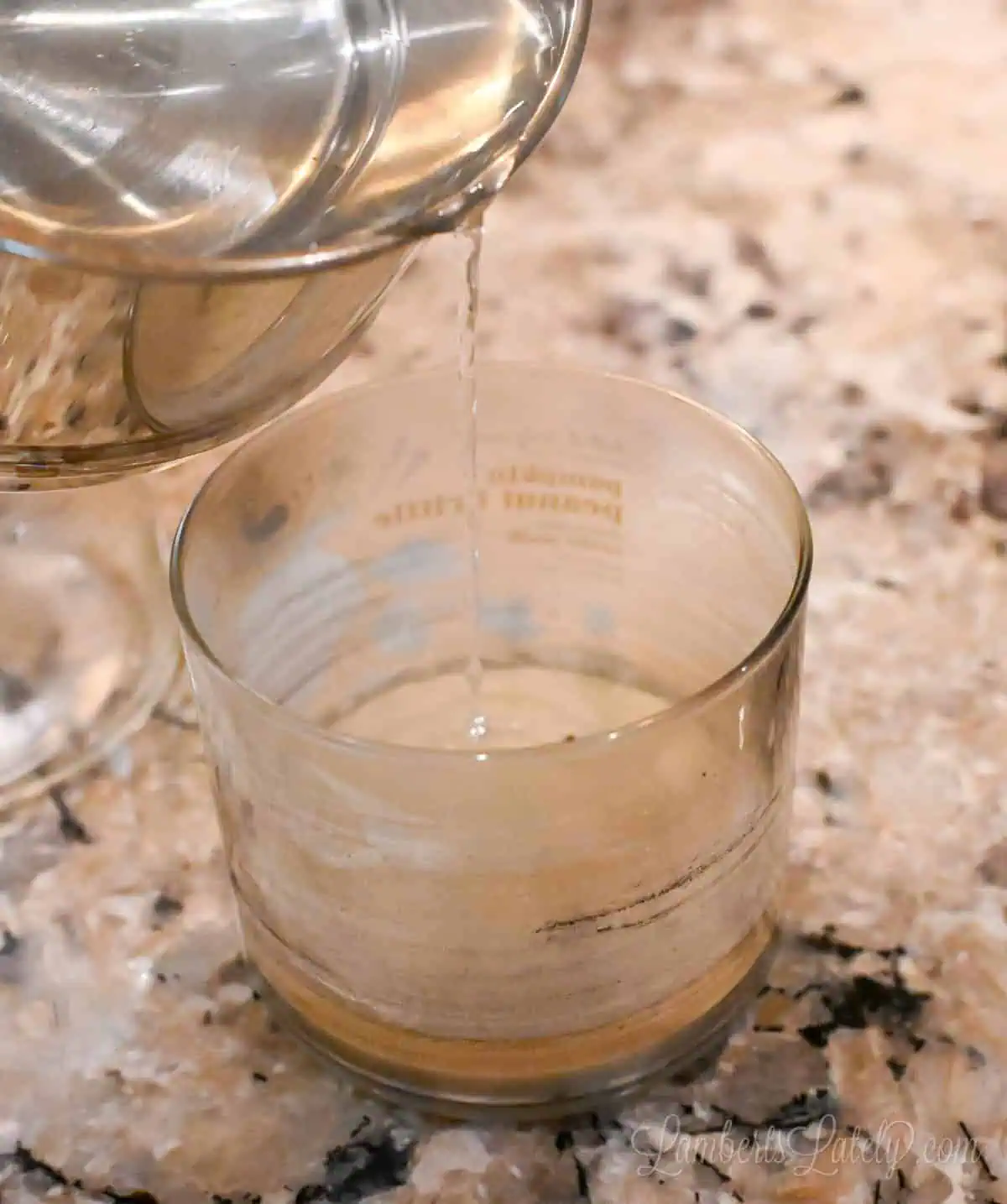 pouring hot water into a used candle jar.