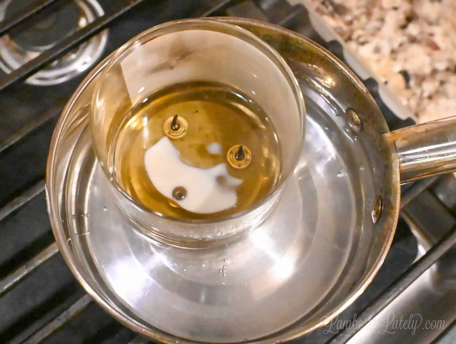 candle melting in water in a saucepan.