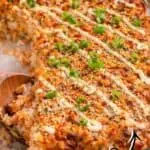 Spicy salmon sushi bake with rice, creamy spicy salmon filling, and green onions.