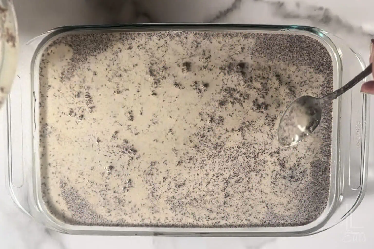 Pouring the three milk mixture over the chocolate tres leches cake.