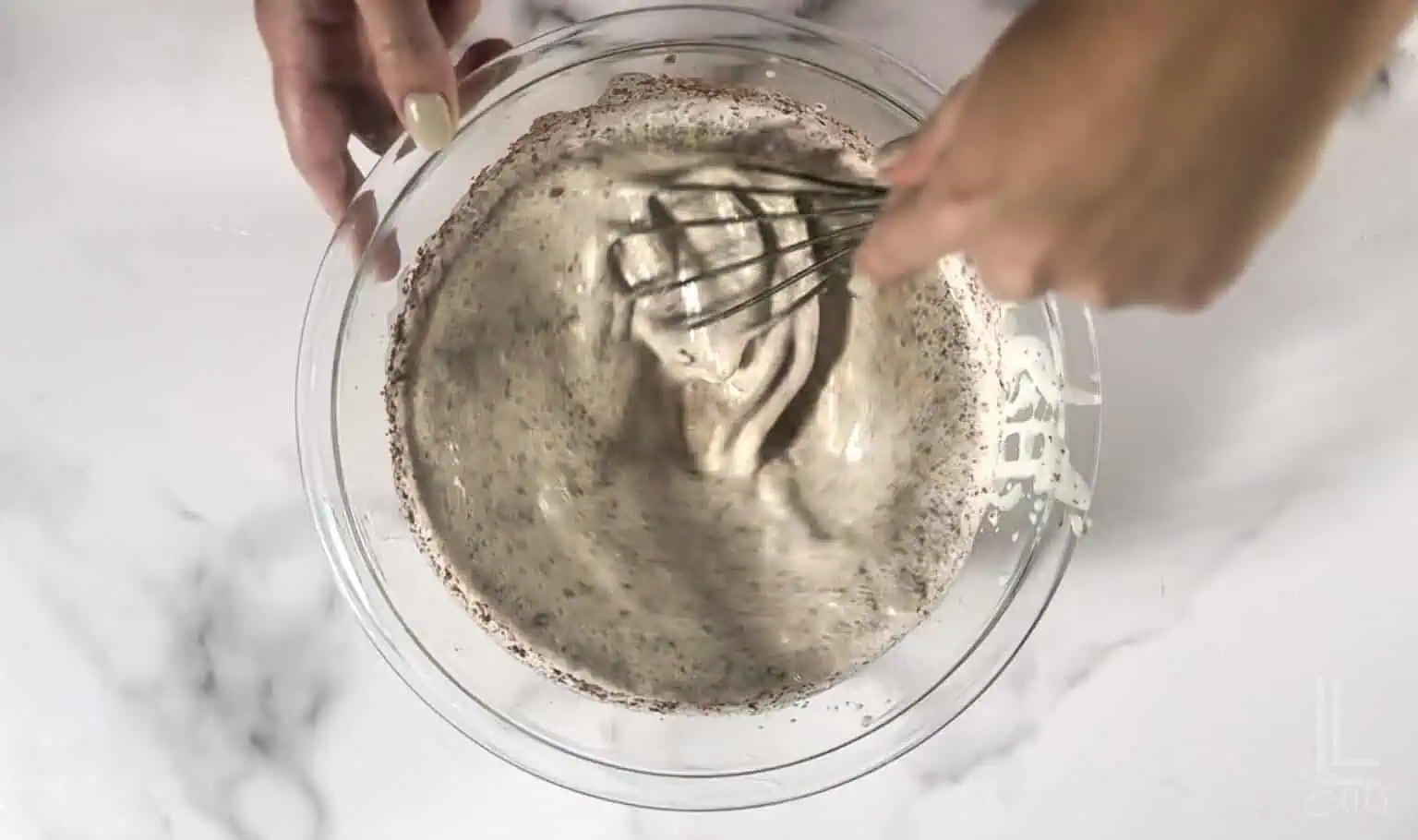 stirring the chocolate three milk mixture in a bowl.