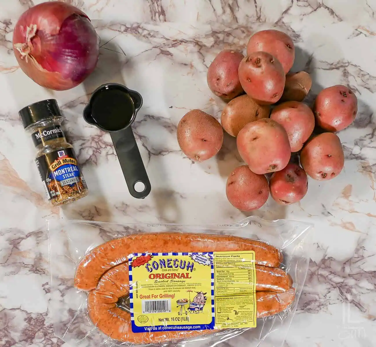 smoked sausage, red potatoes, red onion, olive oil, and seasoning for sheet pan sausage and potatoes.