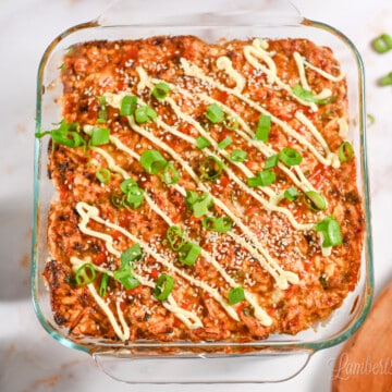 spicy salmon sushi bake in a casserole dish, with a cutting board and avocados.