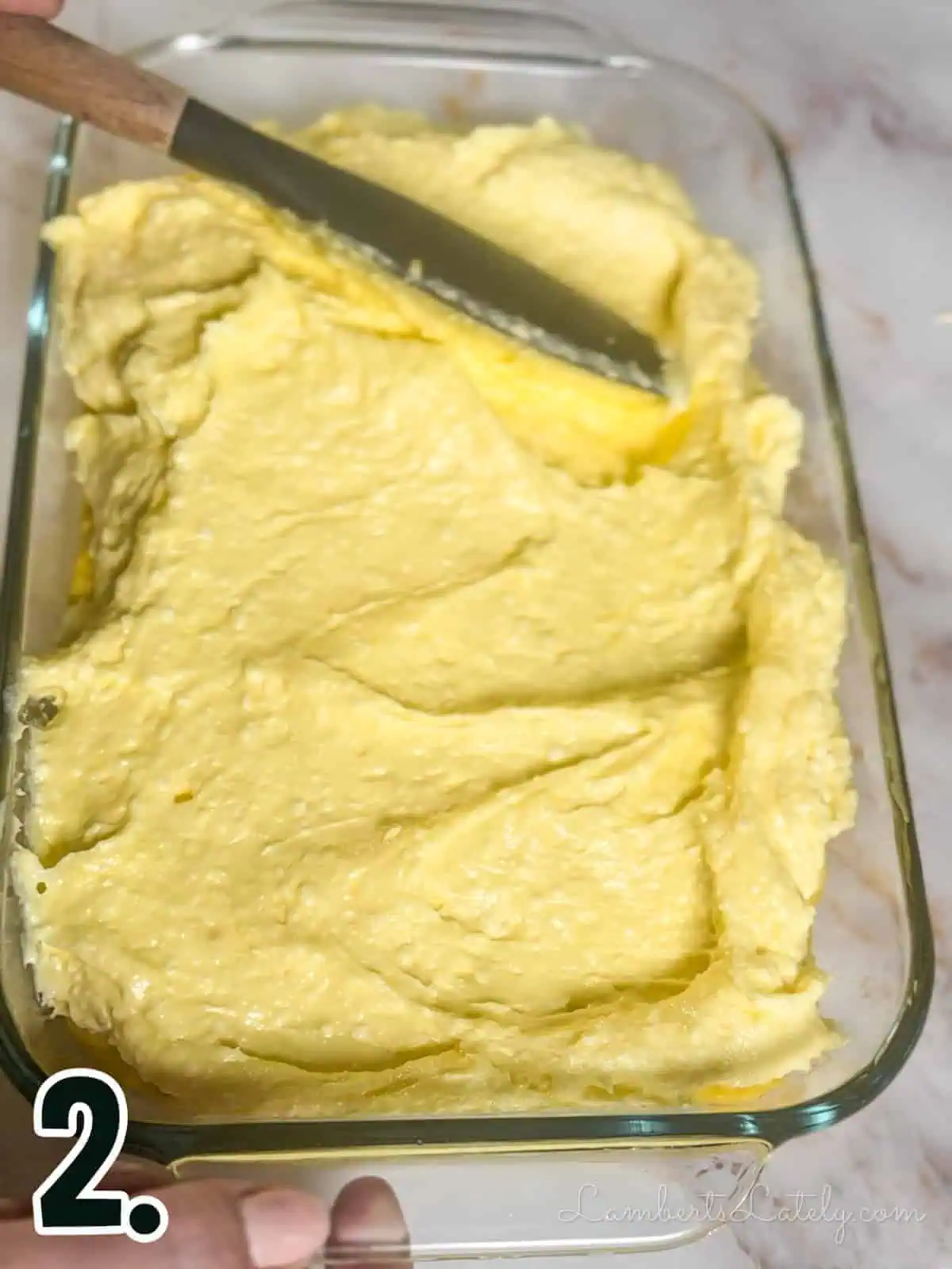 Adding a creamy banana pudding layer to glass baking dish.