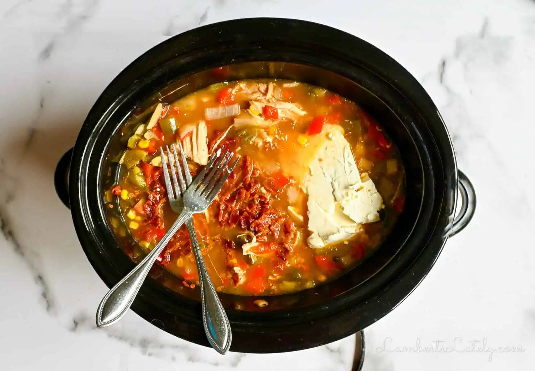 2 forks on top of soup in a crock pot.