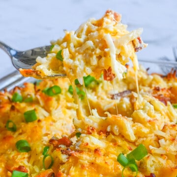 lifting a spoonful of crack potato casserole out of the baking dish.
