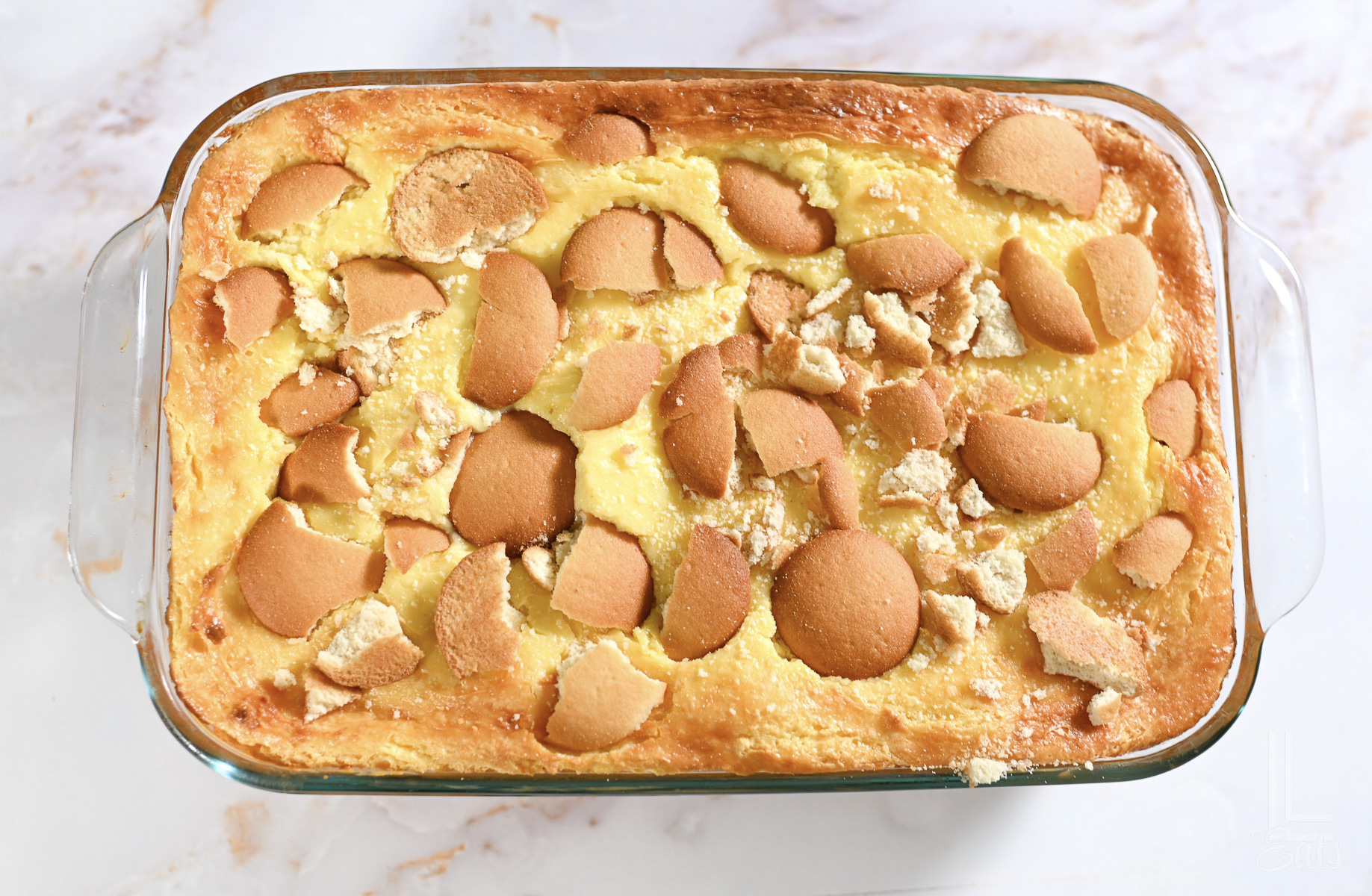 banana pudding brownies in a glass baking dish, after baking, topped with vanilla wafer pieces.