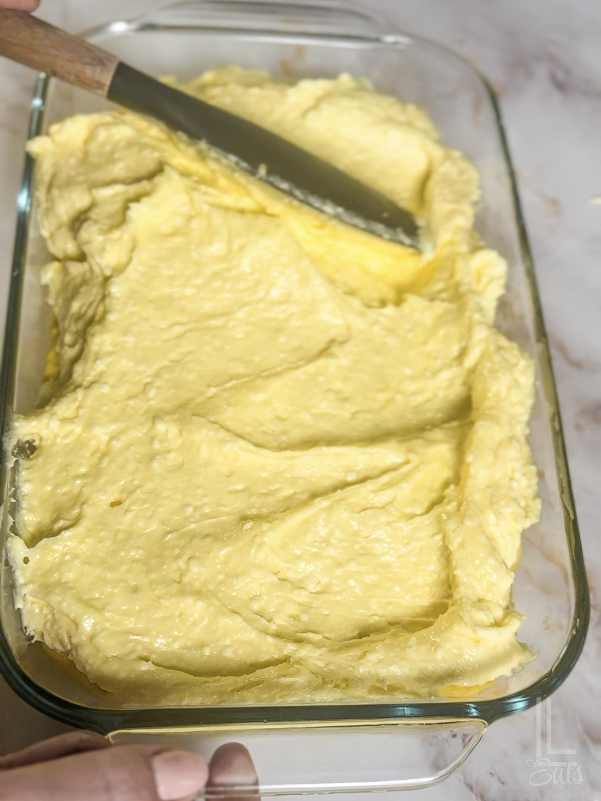 spreading the creamy banana pudding layer over the brownie layer.
