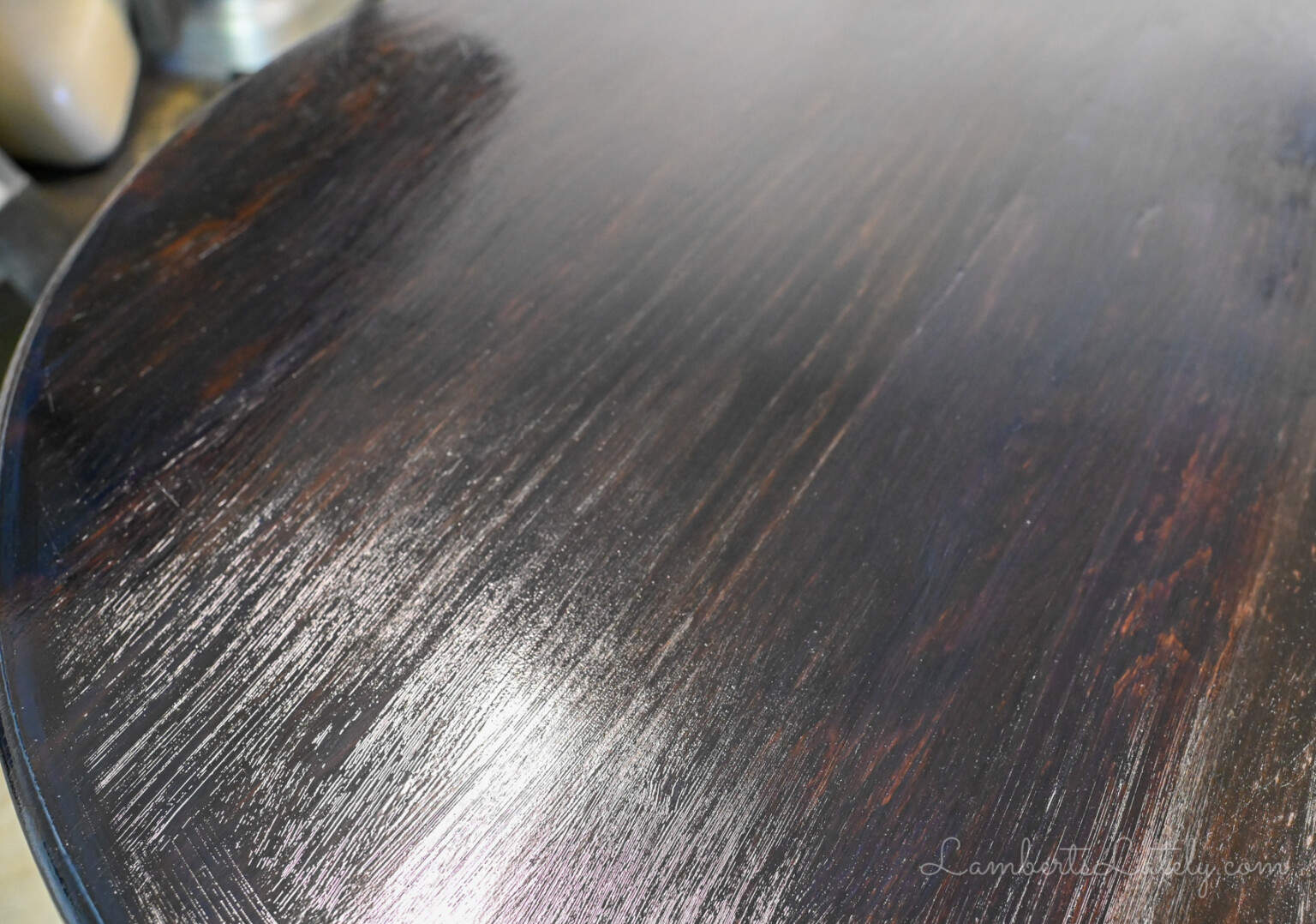 coat of wet polyurethane on a dark stained wood table.