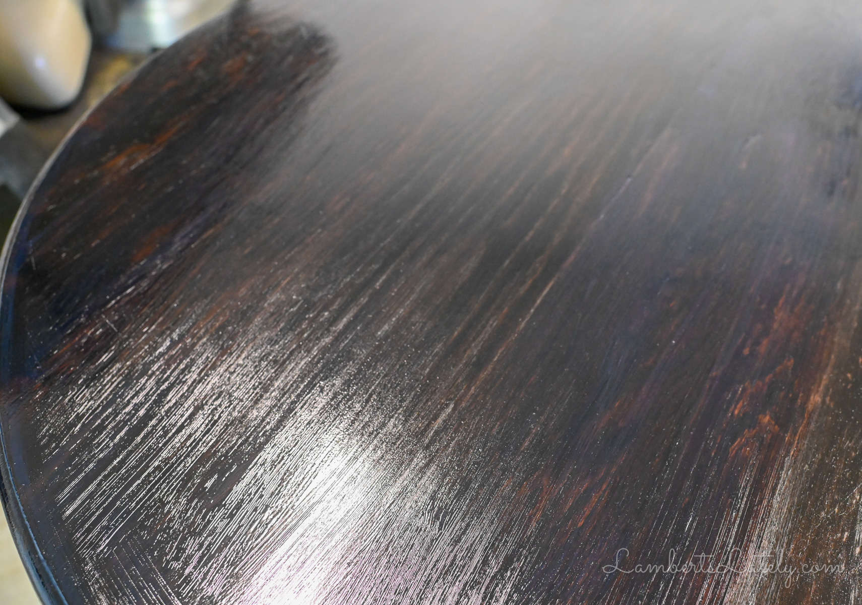 coat of wet polyurethane on a dark stained wood table.