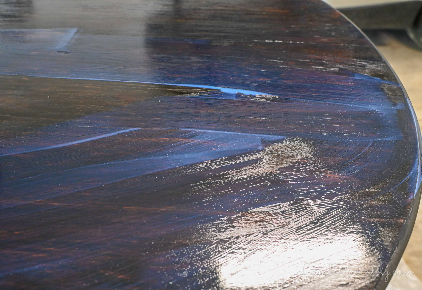 A thick, pooling coat of blue-tinted water-based polyurethane sealer on a tabletop.