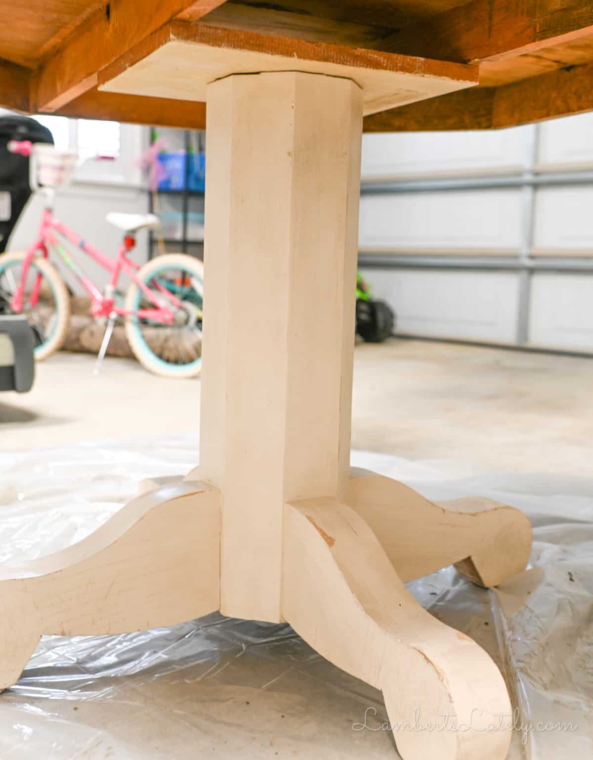 base of a wood table after sanding, with leftover coat of white paint.