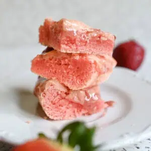 stack of strawberry brownies on a plate.