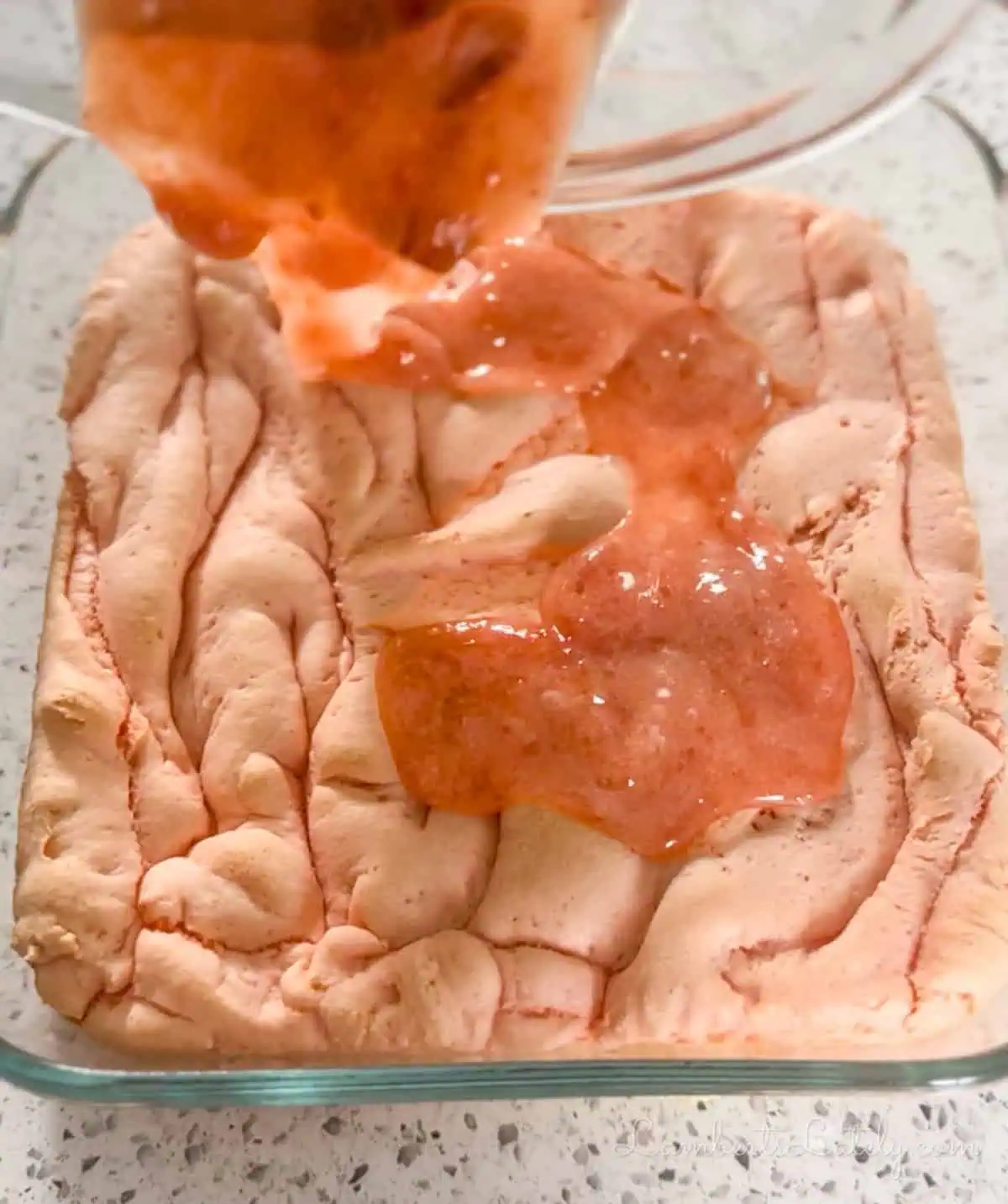 drizzling strawberry glaze over baked brownies.