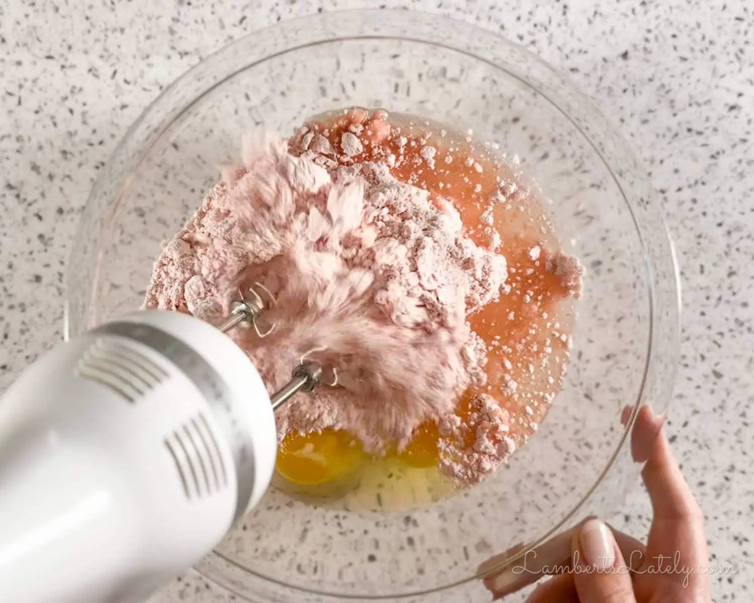blending ingredients in a bowl with a hand mixer.