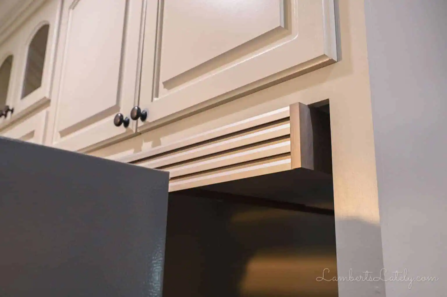 top piece of a fridge trim kit installed in casing.