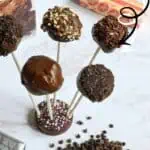 Assorted brownie cake pops with various toppings and flavors on sticks.