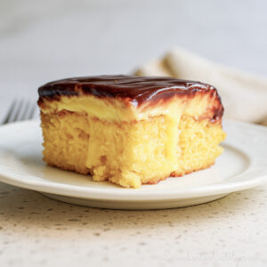 piece of boston cream poke cake on a plate.
