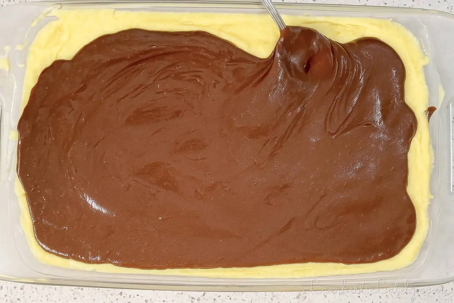 spreading chocolate ganache over pudding layer.