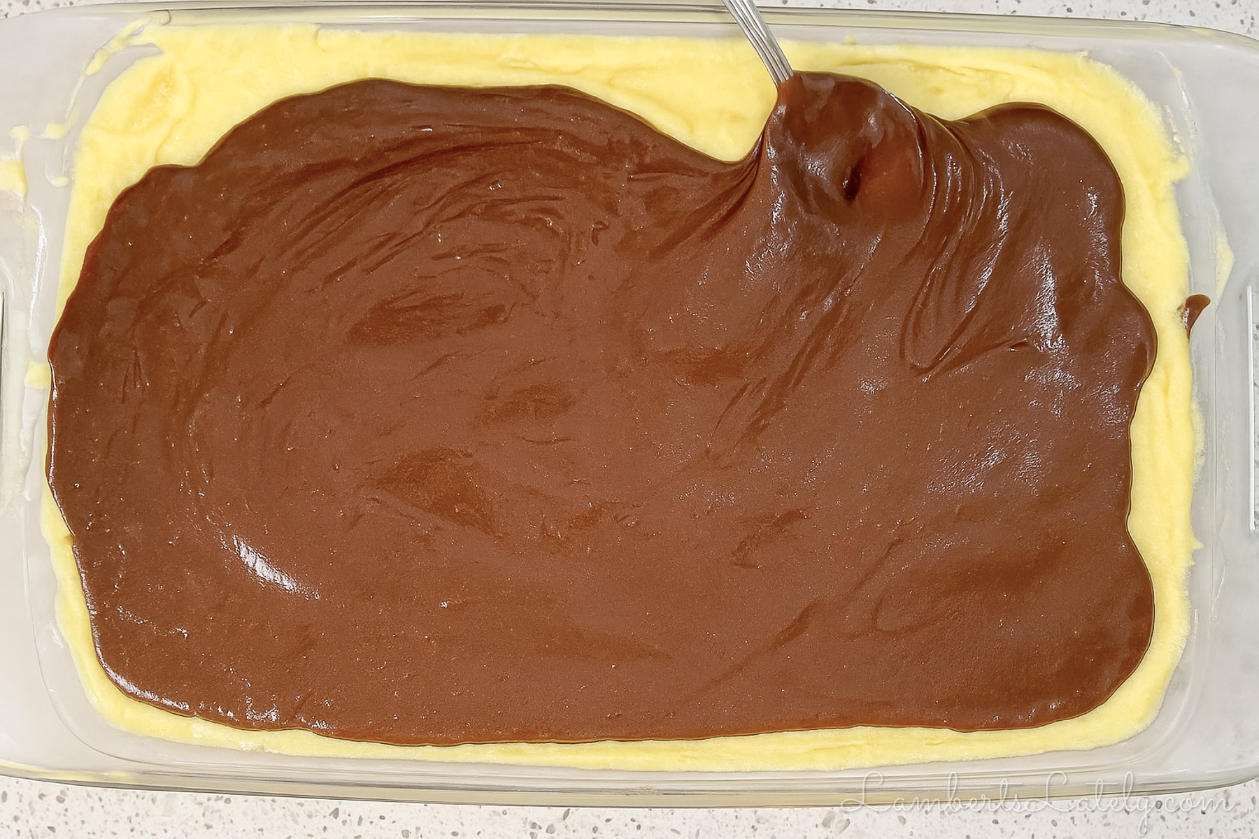 spreading chocolate ganache over pudding layer.
