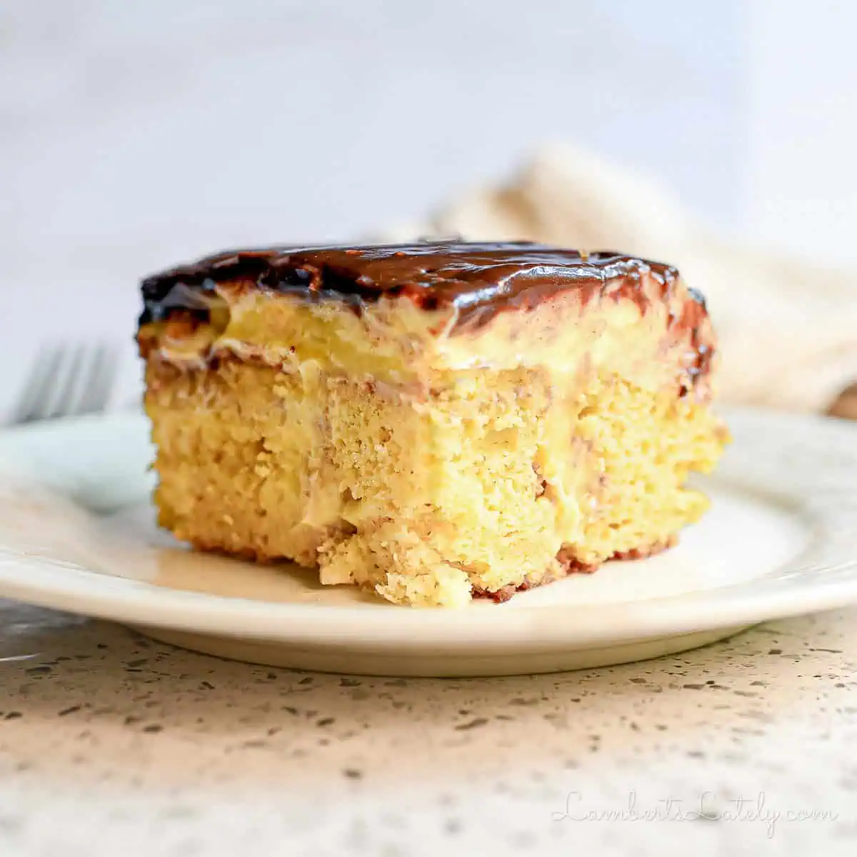 piece of boston cream poke cake on a plate.