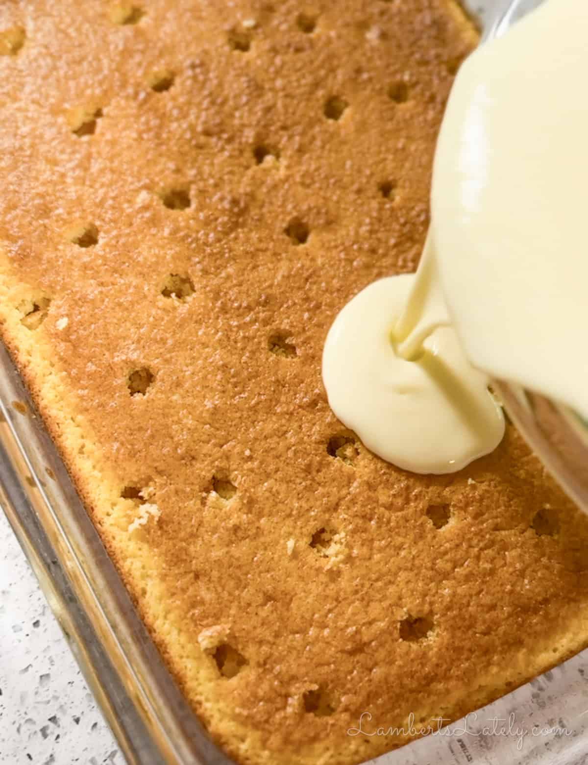 pouring pudding mixture over cake with holes.