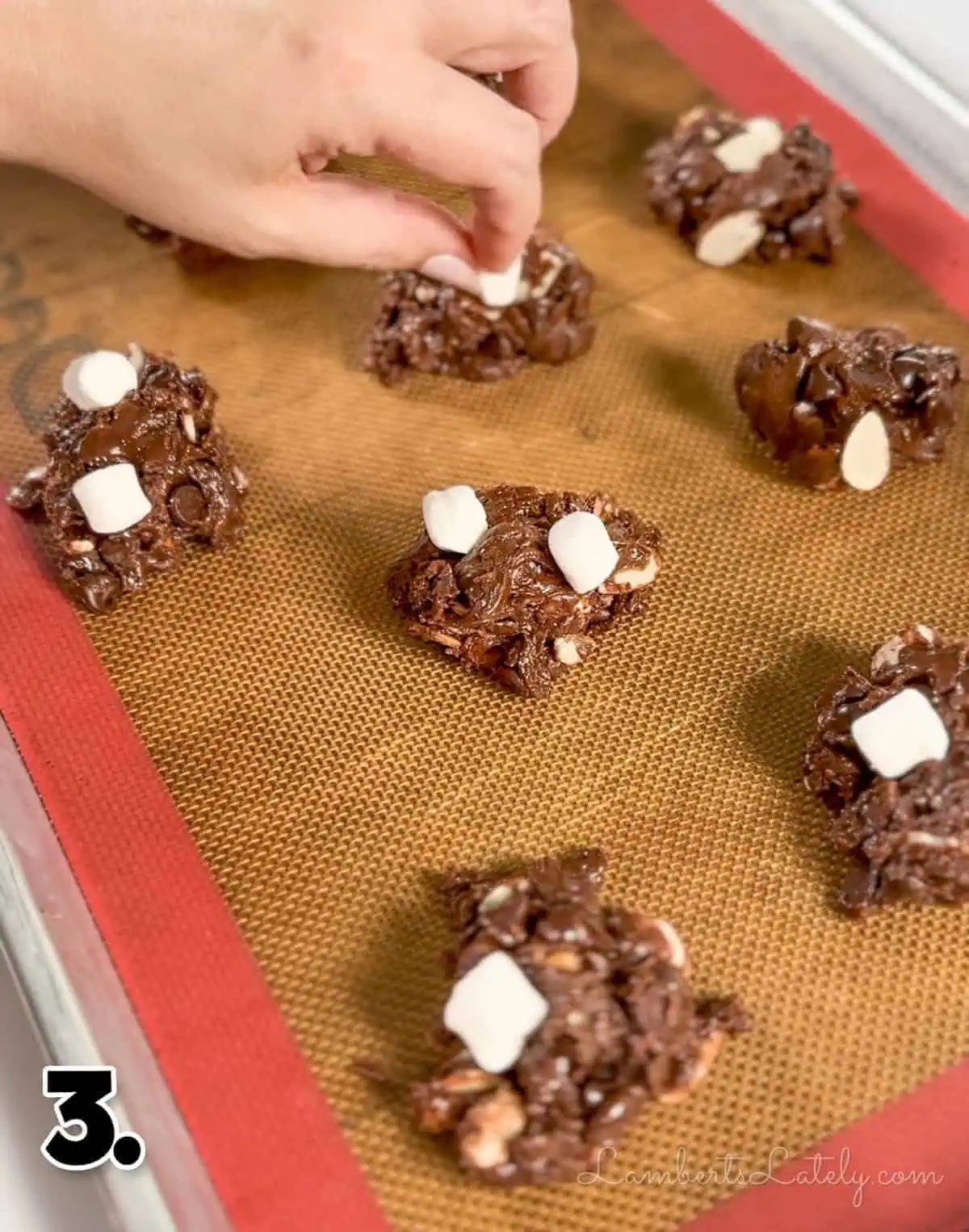 placing marshmallows on top of unbaked rocky road cookies.
