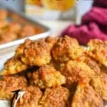 Close-up of golden brown cheddar bay sausage balls on a white plate.