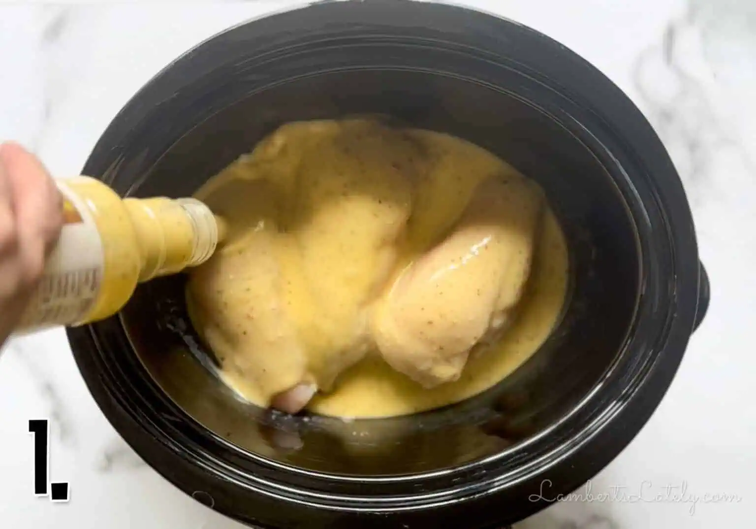 adding salad dressing over chicken breasts in a slow cooker.