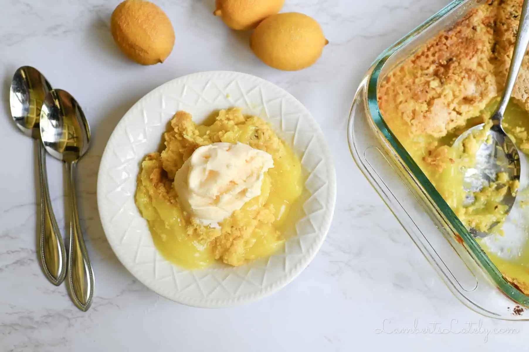 lemon dump cake in a bowl, topped with ice cream, baking dish next to bowl.