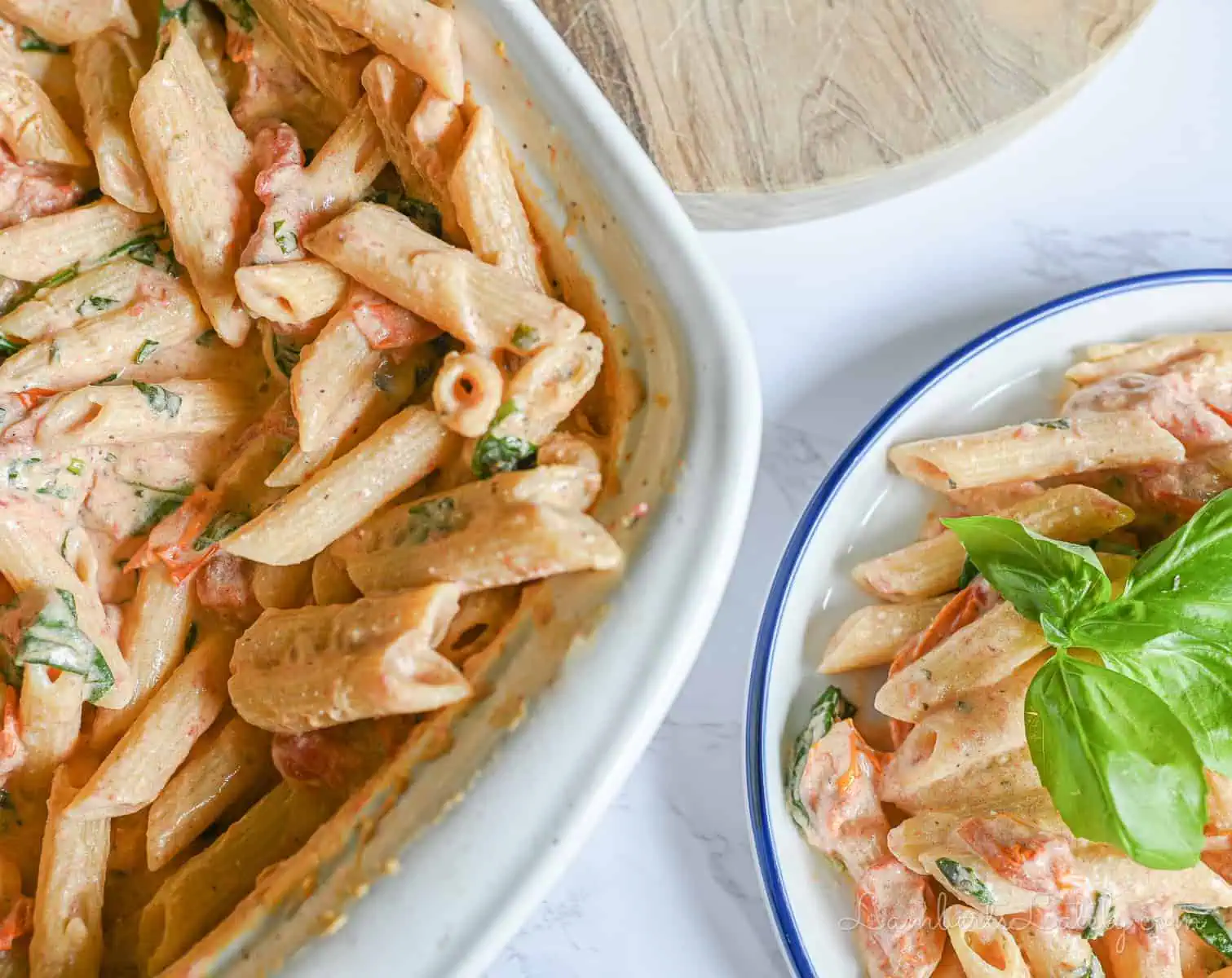 casserole dish full of boursin cheese pasta next to a serving on a plate.