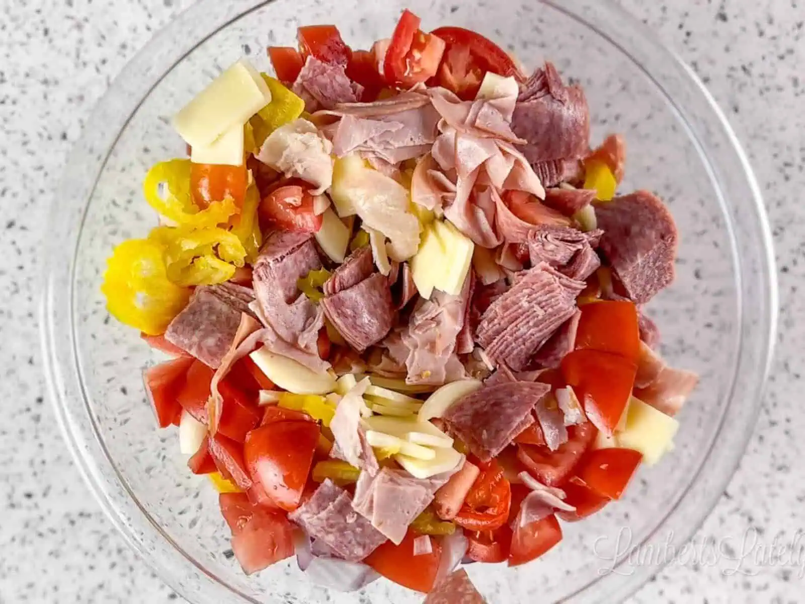 ham, cheese, and vegetables in a glass bowl.