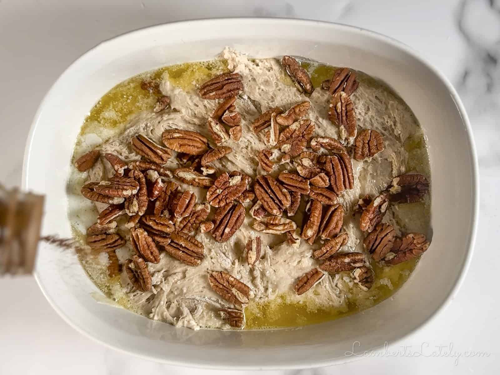 sprinkling cinnamon and pecans over cake mix and butter.