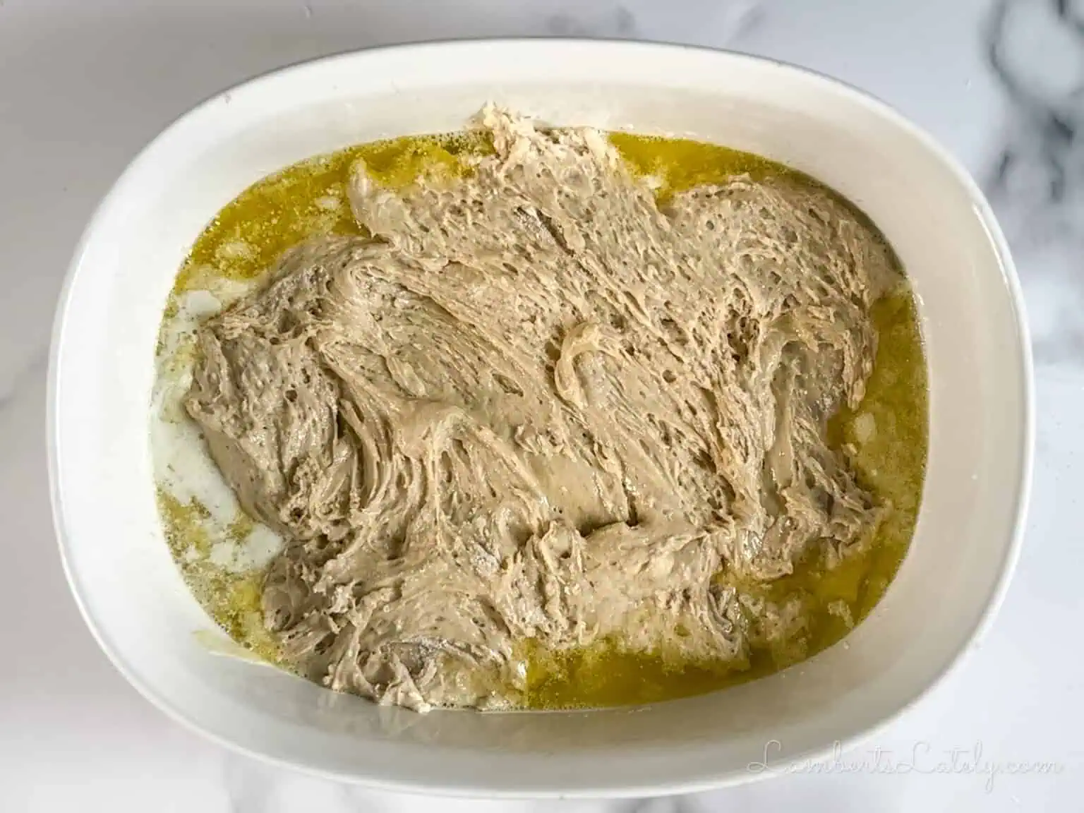 cake batter over butter in a casserole dish.