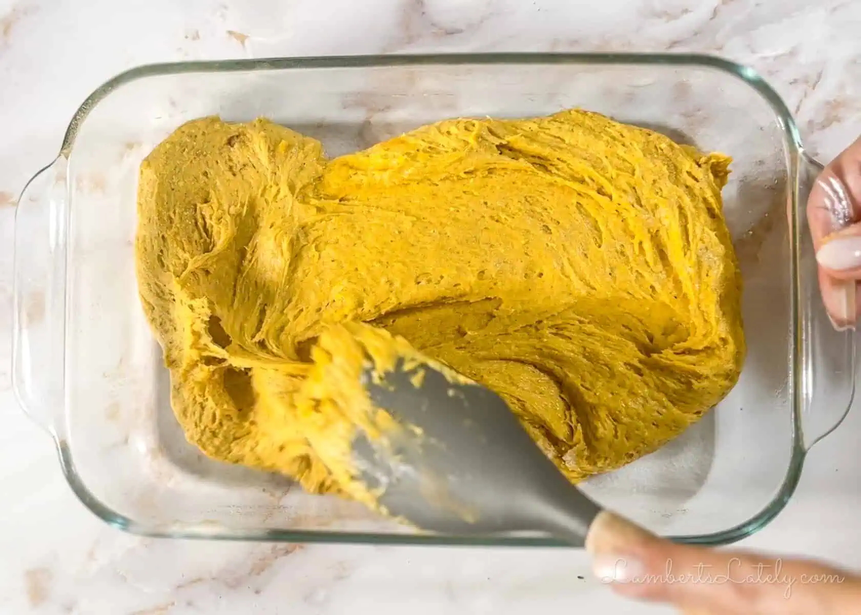 spreading pumpkin bar batter in a glass dish.