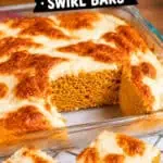 Pumpkin cream cheese swirl bars with golden crust and creamy topping on a glass dish.