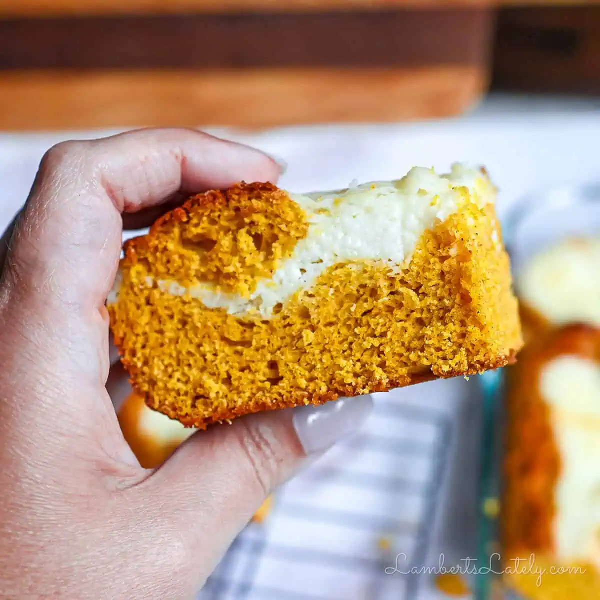 holding a pumpkin bar with cream cheese swirl.