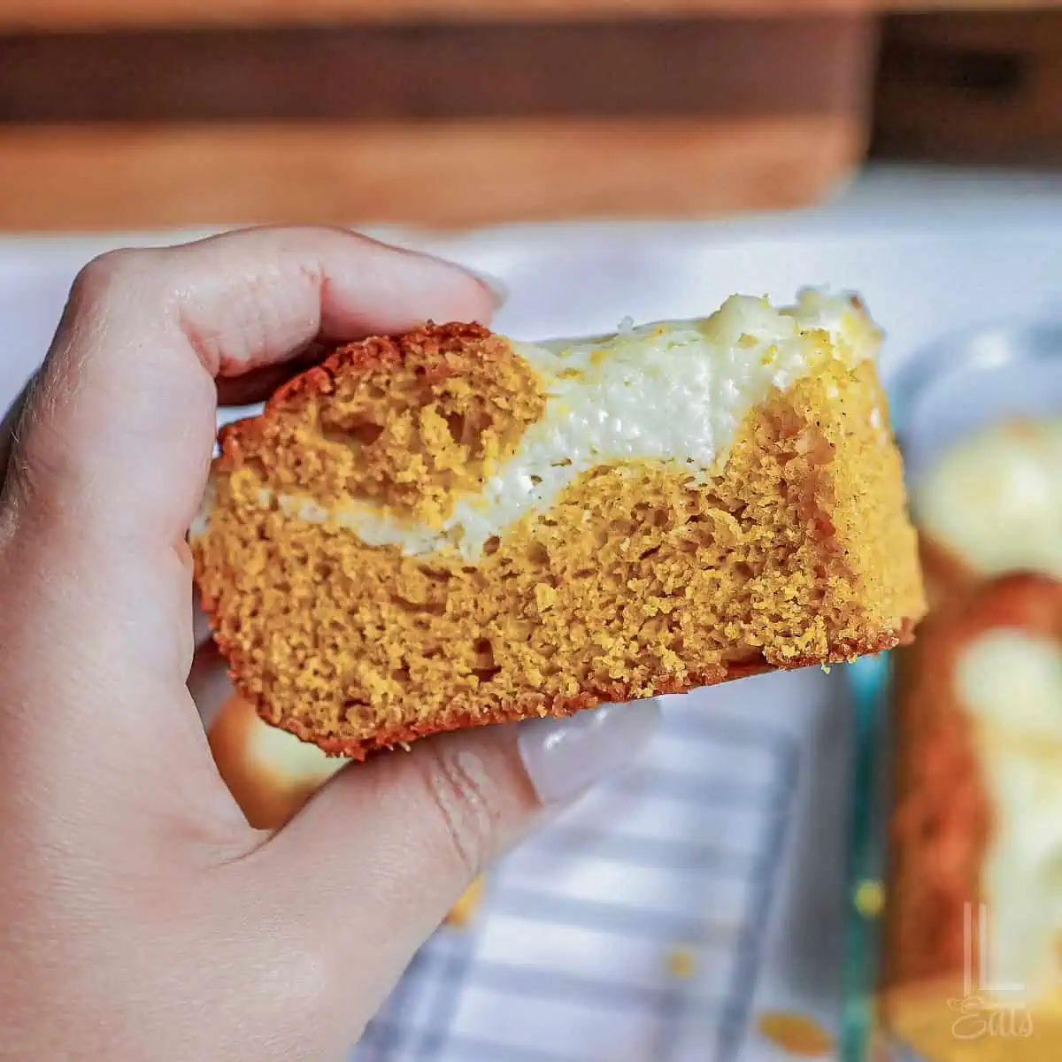 holding a pumpkin bar with a cream cheese swirl.