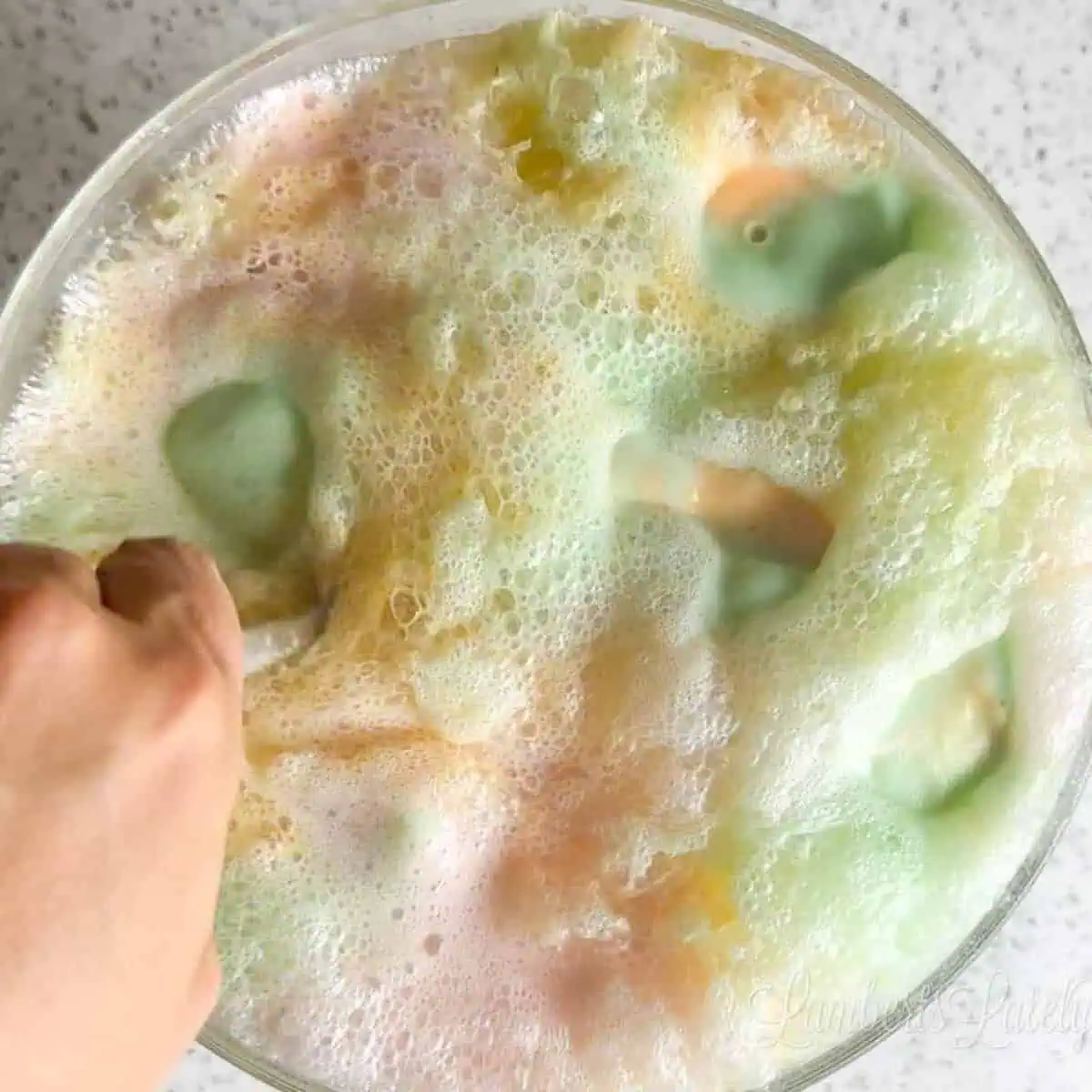 Stirring a punch bowl of Rainbow Sherbet punch.