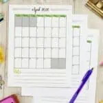 Printable April 2026 calendar with notes section on a desk with stationery.