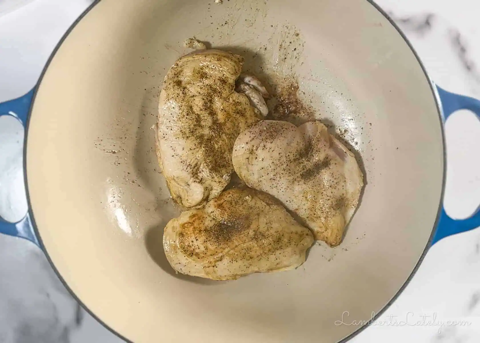 browning chicken in a cast iron pan.