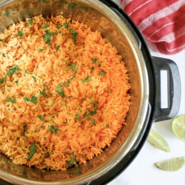 mexican rice topped with cilantro in an instant pot, with limes and a towel next to it.