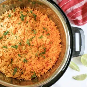mexican rice topped with cilantro in an instant pot, with limes and a towel next to it.