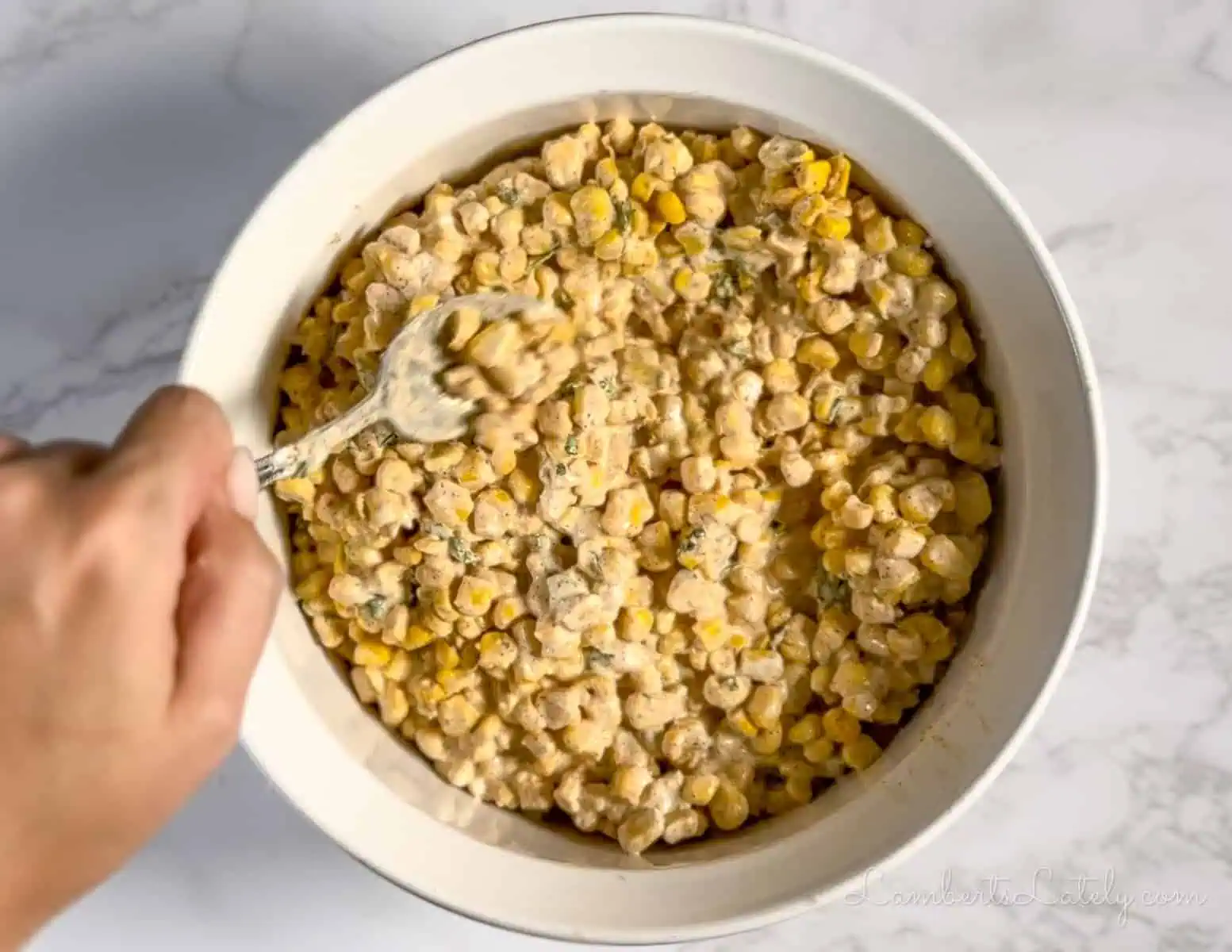 spreading corn casserole in a baking dish.
