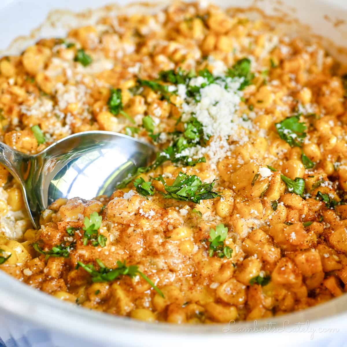 Spoon in creamy Mexican Street Corn Casserole with fresh cilantro.