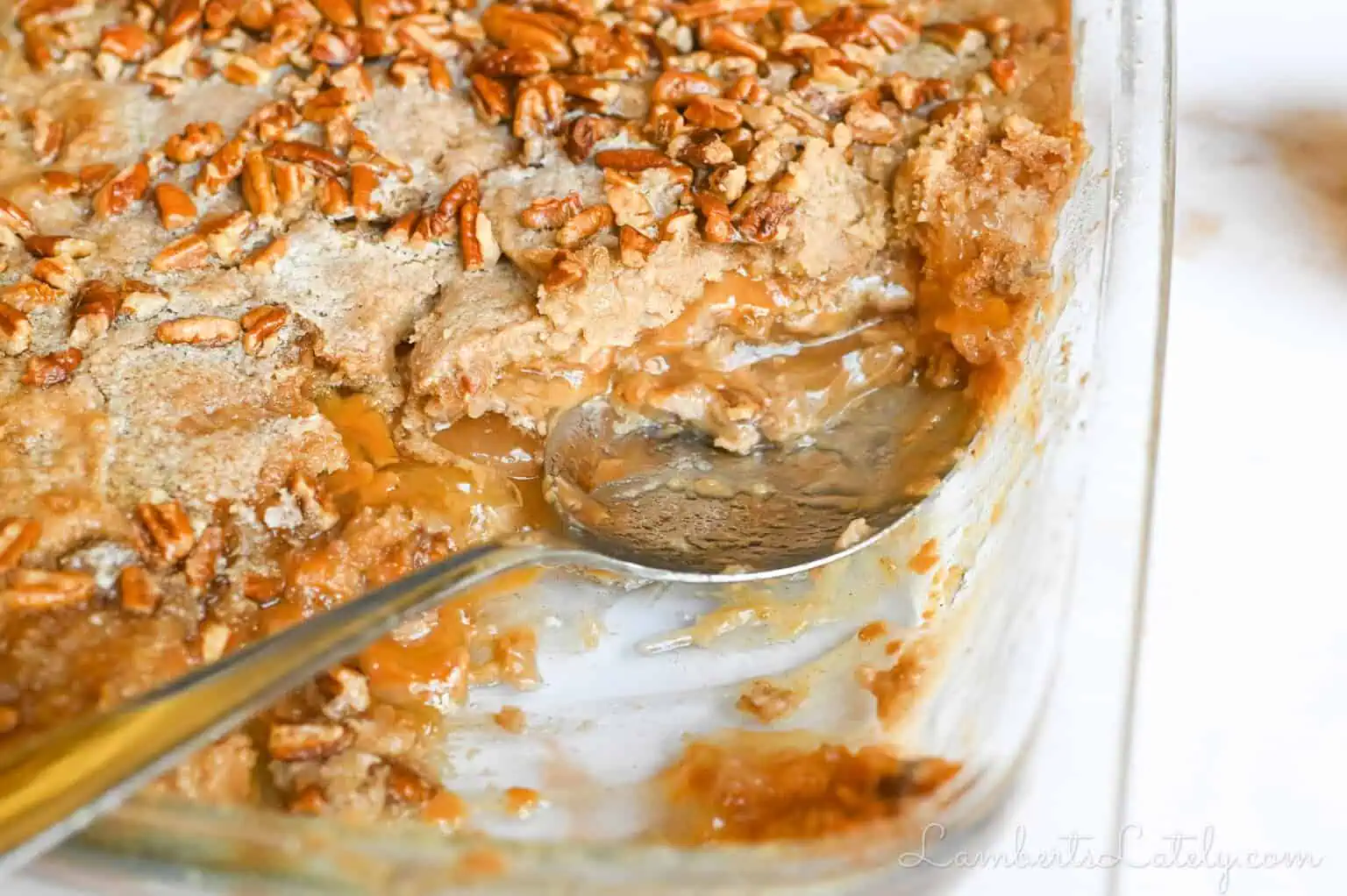spoon in a dish of caramel apple dump cake.