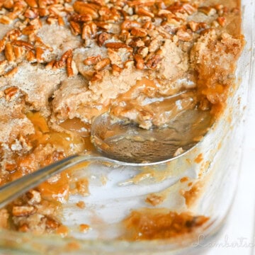 spoon in a dish of caramel apple dump cake.
