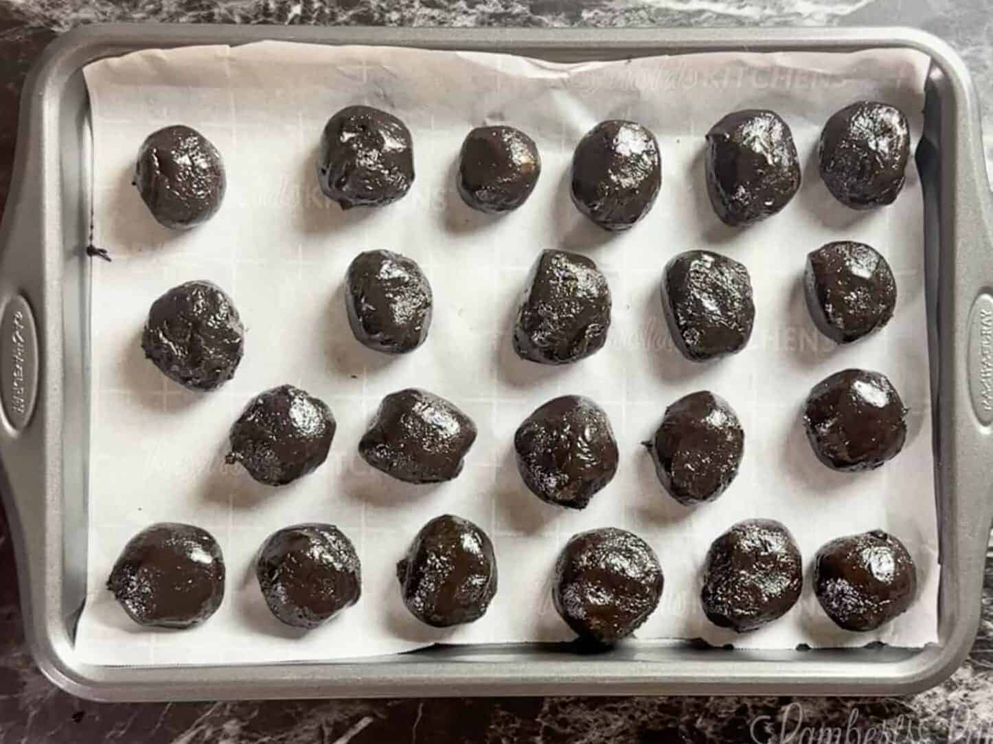 oreo balls on a cookie sheet lined with parchment paper.