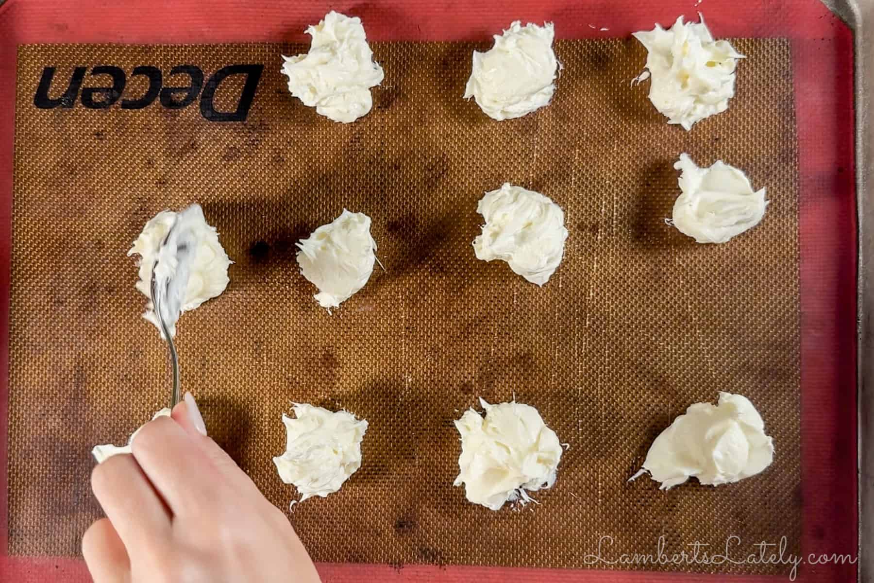 dollops of cream cheese filling on a cookie sheet.