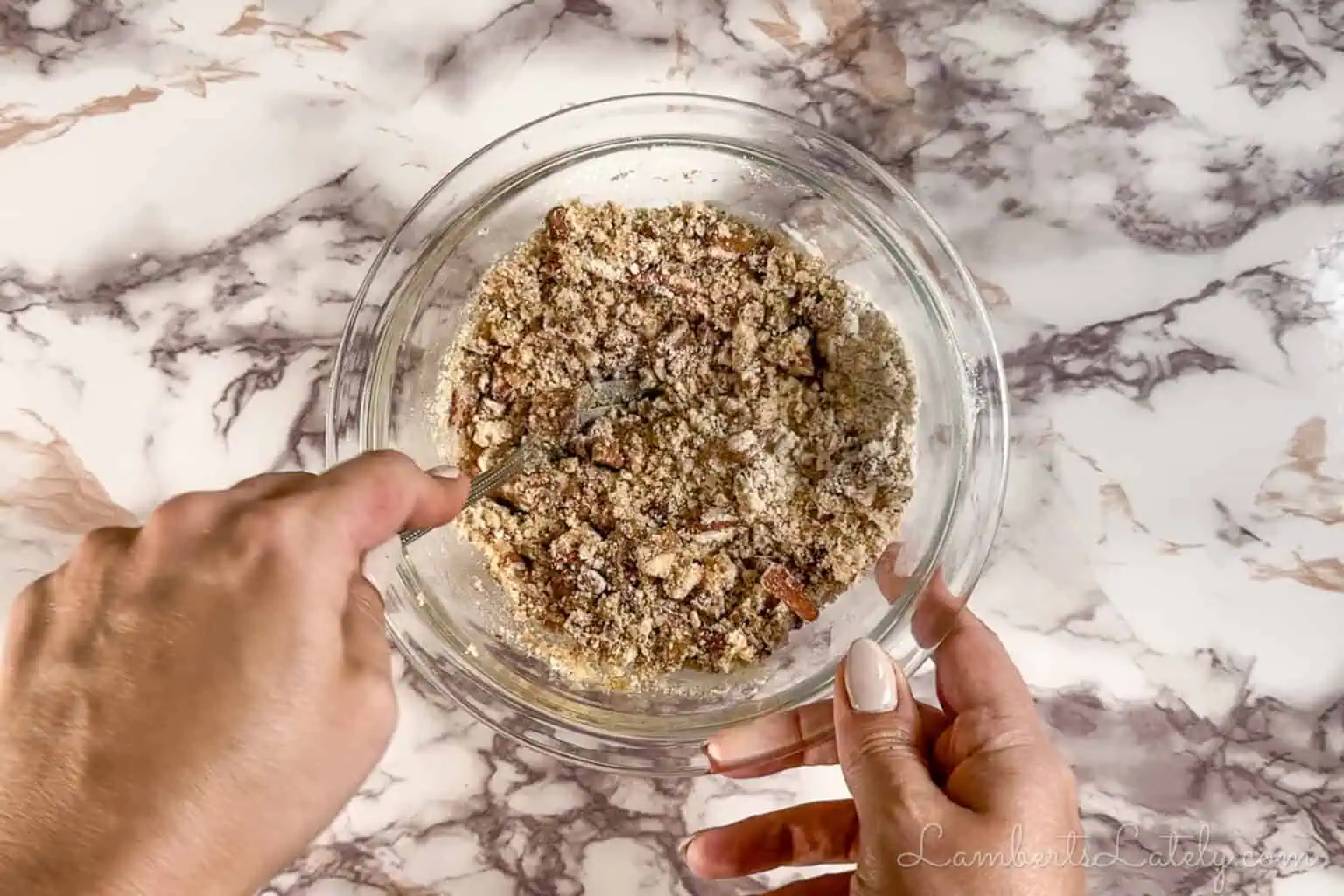 stirring ingredients for a pecan crumble topping in a small glass bowl.